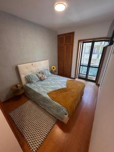 a bedroom with a bed and a large window at RAFURADOURO in Ovar