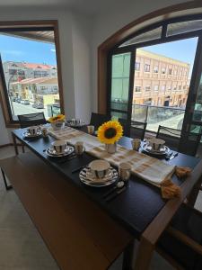 a long table with plates and sunflowers on it at RAFURADOURO in Ovar