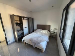 a bedroom with a bed and a desk and a window at appartement Sorgues in Sorgues