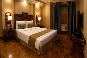 a hotel room with a large bed and a window at Herald Suites Polaris in Manila