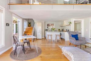 a kitchen and living room with a table and chairs at Magnolia Cottage in Cape Town