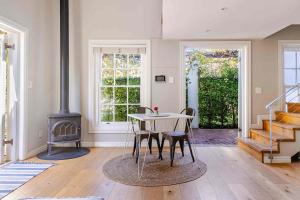 a dining room with a table and a stove at Magnolia Cottage in Cape Town