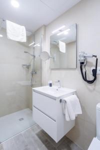 a white bathroom with a sink and a shower at Hotel SAIOLA in Camprodon +20 photos