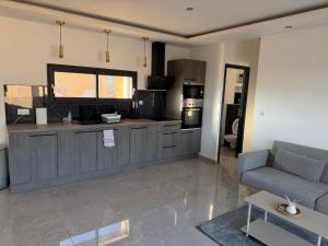 a living room with a couch and a kitchen at appartement Sorgues in Sorgues