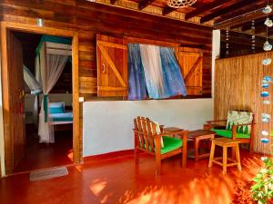 a room with a table and chairs and a bedroom at Mahanoro Hotel & Restaurant in Sainte Marie