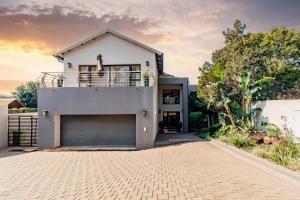 a white house with a garage at Braham Lodge - The Octave 5 in Johannesburg