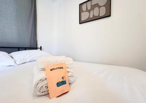 a book sitting on top of a bed with towels at Studio Cosy Pont-Saint-Maxence in Pont-Sainte-Maxence
