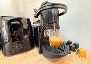 a coffee maker with a glass in front of a toaster at Studio Cosy Pont-Saint-Maxence in Pont-Sainte-Maxence