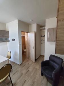 a living room with a couch and a chair at LŰN Apartman in Dunaföldvár +12 photos