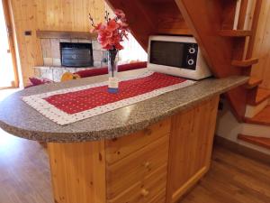a kitchen counter with a microwave and a vase with flowers at Heidi Montelivata in Subiaco +2 photos