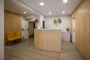 an office lobby with a counter and yellow chairs at Hotel SAIOLA in Camprodon