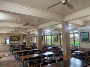 a dining room with tables and chairs and windows at Bavieco Resort in Yên Bài