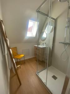 a bathroom with a glass shower and a chair at Four Bas in Martel