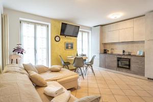 a living room with a couch and a kitchen at Casa Cataleya, Tuenno Ospitar in Tuenno