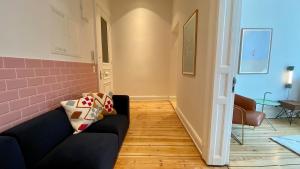 a living room with a black couch and a pink wall at STACEY Downtown in Hamburg +5 photos