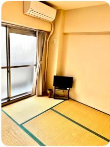 an empty room with a window and a piano in it at パールビル201 in Osaka