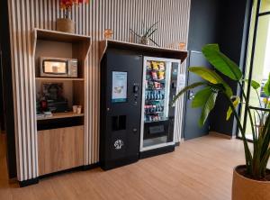 a soda vending machine in a room with a tv at B&B HOTEL Valenciennes Onnaing 3 étoiles Parc d Activités de la Vallée de l Escaut in Onnaing +37 photos