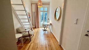 a hallway with stairs and a desk and a mirror at STACEY Downtown in Hamburg