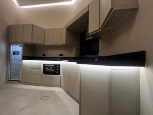 a kitchen with white cabinets and a stove at هابينيس شاليه in Salalah
