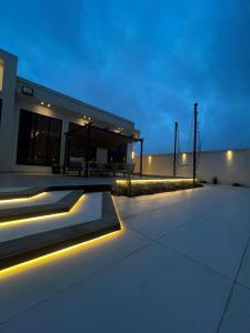 a house with lights on the side of it at هابينيس شاليه in Salalah