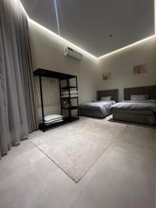 a bedroom with two beds and a rug at هابينيس شاليه in Salalah