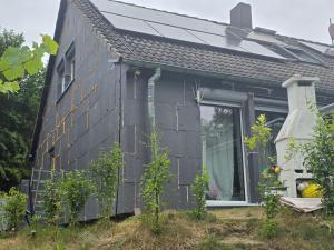 a black house with a window on the side of it at Ferienwohnung Burmester von Privat! in Wittenborn