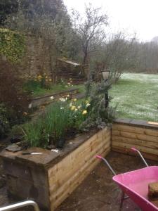 a garden in the rain with a table and flowers at Holly Cottage in Banbury