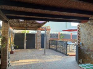 a patio with a fence and a table with an umbrella at Chalet en Costacabana in Costacabana