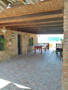 a patio with a table and benches and a stone wall at Chalet en Costacabana in Costacabana