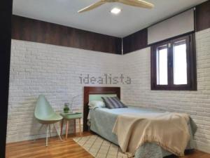 a bedroom with a bed and a brick wall at Chalet en Costacabana in Costacabana