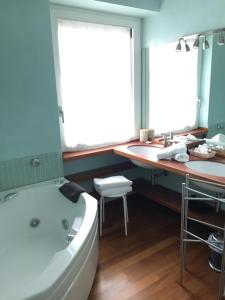 a bathroom with a tub and two sinks and a bath tub at Giardino Segreto in Peschiera del Garda