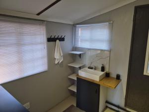 a bathroom with a sink and a counter and window at Toekoms Inn in Aliwal North