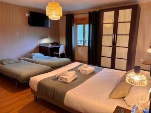a hotel room with two beds with towels on them at La Tour Des Lys in Maubeuge