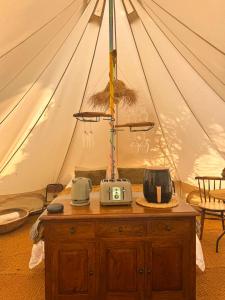a tent with a wooden dresser with a tv on it at The Pip and Lantern in Rye