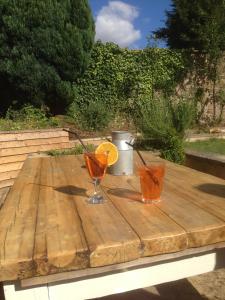 a wooden table with two glasses and a slice of orange at Holly Cottage in Banbury