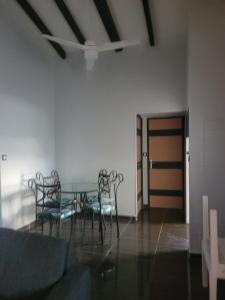 a dining room with chairs and a table and a ceiling at Entre terre et ciel in Baie-Mahault