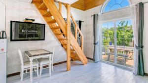 a living room with a staircase and a table and chairs at Youngheungdo Roma Spa Pension in Incheon