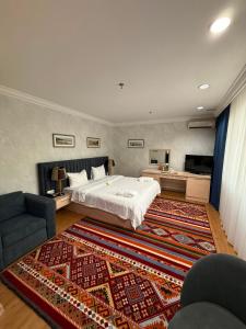 a bedroom with a large bed and a rug at King Hotel Astana in Astana +145 photos