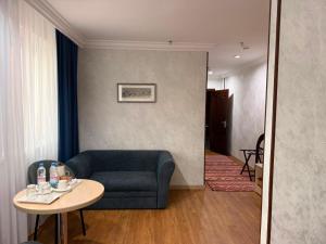 a living room with a blue couch and a table at King Hotel Astana in Astana