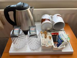 a tray with cups and utensils on a table at Adam Place Guest House in Windermere +29 photos