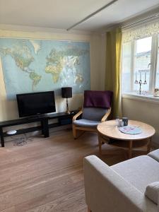 a living room with a tv and a couch and a table at Charming, quiet apartment in Kvissleby