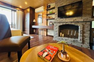 a living room with a fireplace with a tv above it at Crosswinds Nature View Suite in Tagaytay