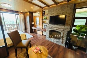 a living room with a fireplace and a television at Crosswinds Nature View Suite in Tagaytay