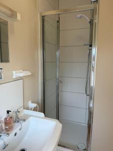 a bathroom with a sink and a shower at Adam Place Guest House in Windermere