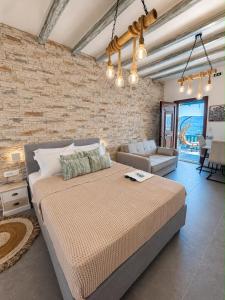 a bedroom with a large bed and a brick wall at Miloa Klima View 'Syrma' in Klima