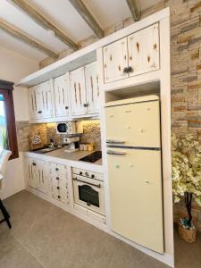 a kitchen with white cabinets and a refrigerator at Miloa Klima View 'Syrma' in Klima
