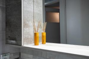two yellow vases sitting on a shelf in a bathroom at Amarysia Residence in Athens