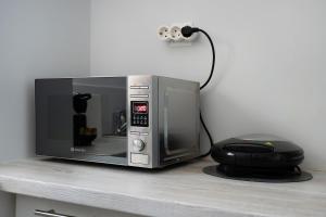 a microwave sitting on top of a counter with a phone at Amarysia Residence in Athens