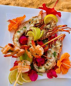 a plate of shrimp and vegetables on a table at Appartement Les Vagues Vue sur Mer pour familles in Oualidia
