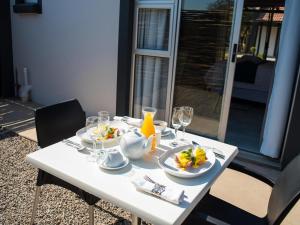 a white table with plates of food on it at Meloding Guest House in Bela-Bela